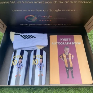 football gift box open showing socks, autograph book and shin pads.