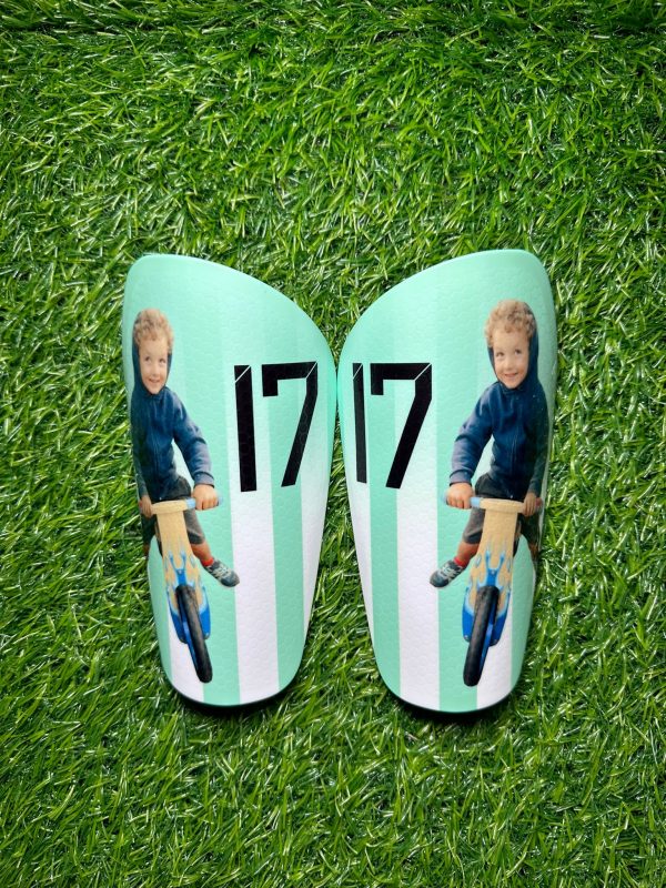 Elite personalised shin pads. Turquoise and white backdrop with family photo.