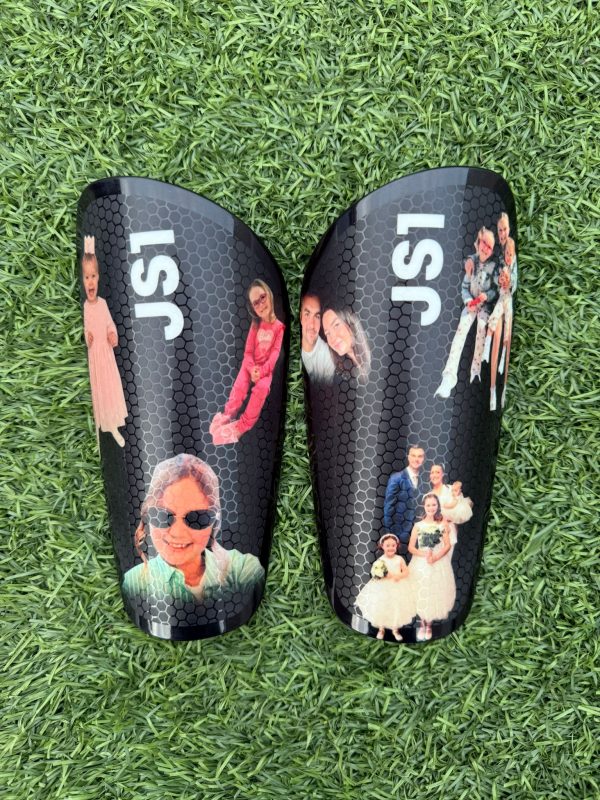 Elite personalised shin pads black background with family and JS1 design.