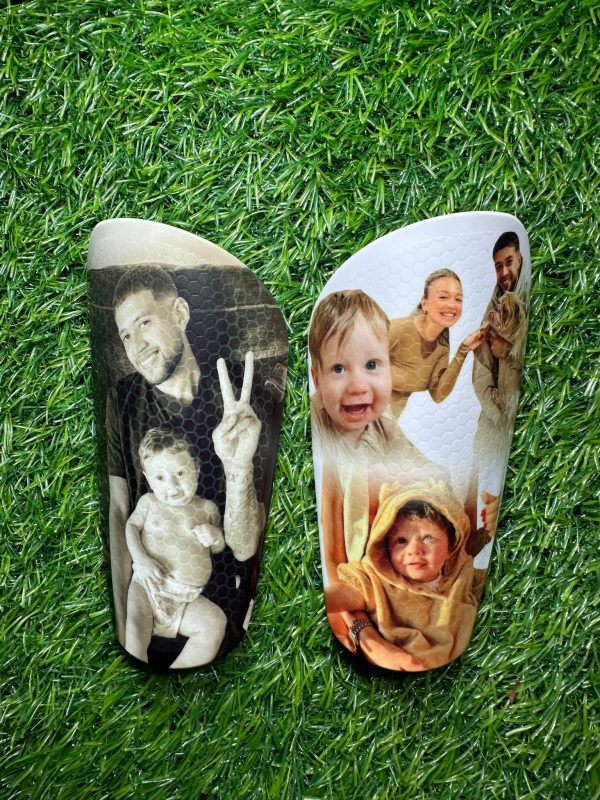 Elite personalised shin pads with black and white design and vibrant design with family.