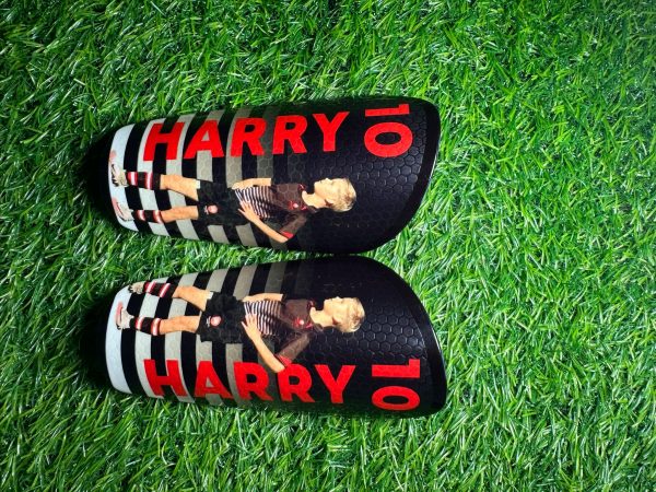 Elite personalised shin pads. Black and white pads with red text.