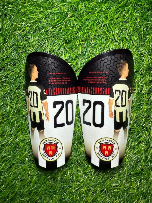 Elite personalised shin pads. Black white backdrop with red text and grassroots logo.