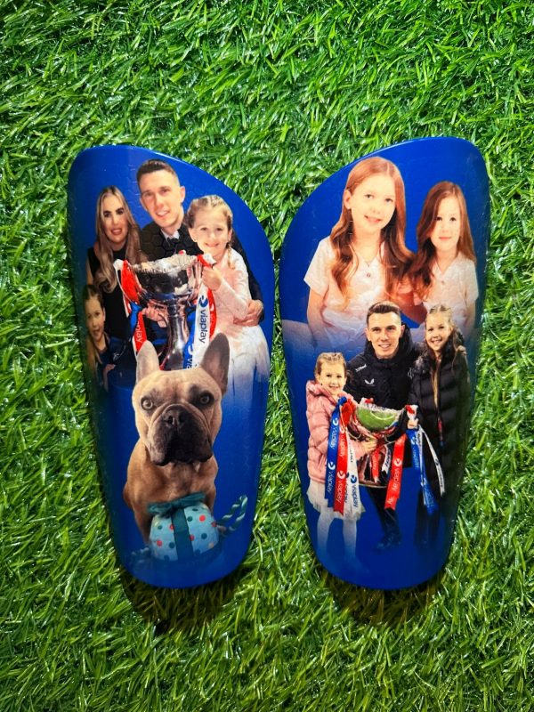 Elite personalised shin pads with blue background and family design.