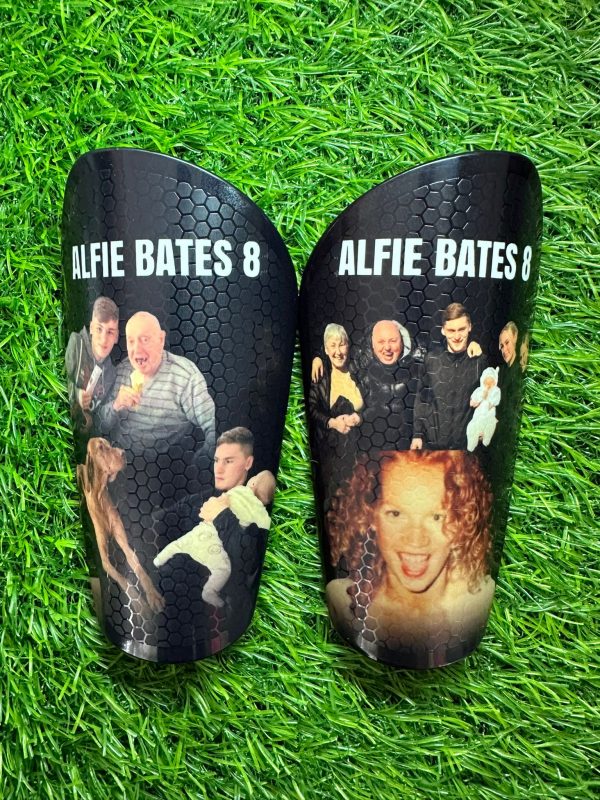Elite personalised shin pads black background with family design.